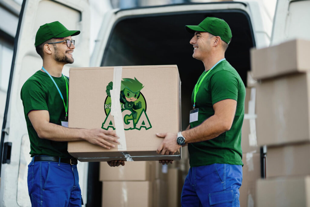Helfer tragen einen Karton vor einem Transporter